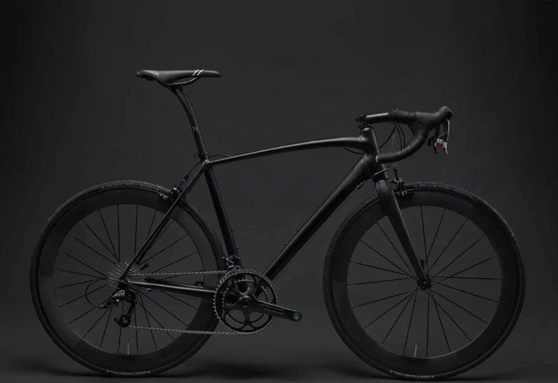 A black racing bike in front of a black background.